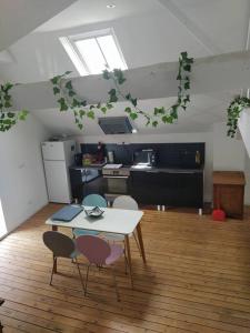 a room with a table and chairs and a kitchen at charmant loft aménagé in Vivonne