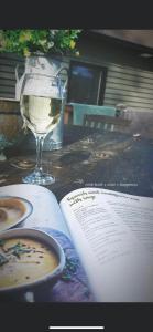 阿博因的住宿－Birchwood View，一张桌子上的开放式书,上面放着一杯葡萄酒