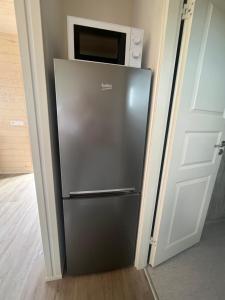a stainless steel refrigerator in a room with a microwave at Skógsnes II in Selfoss