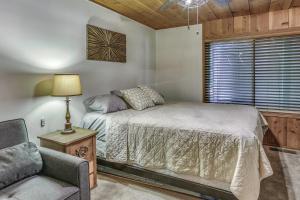 1 dormitorio con 1 cama, 1 silla y 1 ventana en Cozy Bears Hideaway about 3 Mi From Shaver Lake!, en Shaver Lake