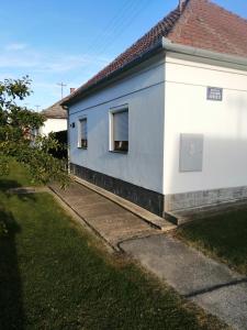 Soba LIPA في Valpovo: مبنى أبيض مع نافذة وساحة عشبية