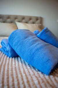 una manta azul sentada encima de una cama en Harmony Studio Apartment, en Jagodina