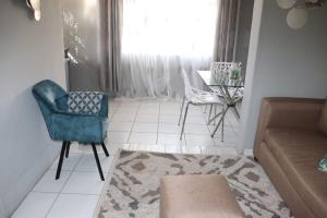 a living room with a couch and a chair and a window at Unitrainview guest house in Pretoria