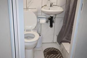 a small bathroom with a toilet and a sink at Unitrainview guest house in Pretoria