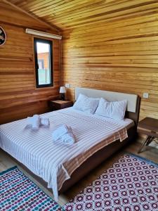 een slaapkamer met een groot bed in een houten kamer bij Arlin Bungalows in Kemer
