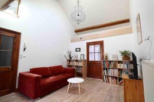 Una sala de estar con un sofá rojo y una mesa. en Superbe appartement T5 - Les Hauts du Château, en Chambéry