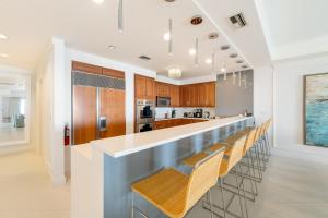 a kitchen with a long bar with stools at Beach Front Residence 108 located at The Ritz-Carlton in Upper Land