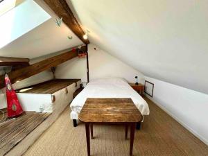 - une chambre mansardée avec un lit et une table dans l'établissement Les Hauts du Château, à Chambéry