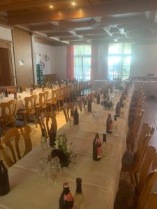 a long table in a room with wine bottles on it at Brauerei Gasthof Kraus in Hirschaid
