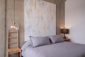 a bedroom with a bed and a painting on the wall at Galeria Flat Rooftop Pool Witgdl in Guadalajara
