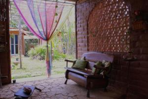 - un salon avec un canapé et une fenêtre dans l'établissement Espaço Shanti - Chalés, à Sao Jorge