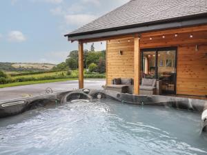 a swimming pool in front of a house at Harp Meadow in Presteigne