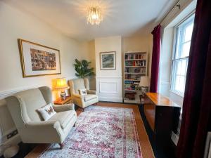 a living room with two chairs and a table at Church End Cottage, Brampton in Brampton