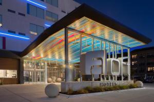 a building with a sign in front of it at Aloft Omaha Aksarben Village in Omaha