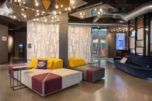 a living room with a couch and chairs in it at Aloft Omaha Aksarben Village in Omaha