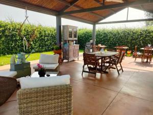 patio cubierto con mesa, sillas, mesa y silla en Villa Albina, en La Loggia