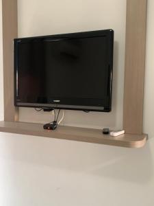 a flat screen tv sitting on a shelf at APART HOTEL JURERE in Florianópolis