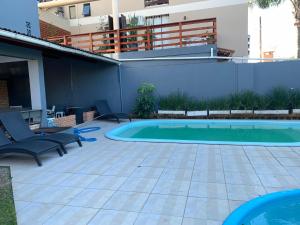 a patio with a pool and chairs and a building at APART HOTEL JURERE in Florianópolis +7 photos