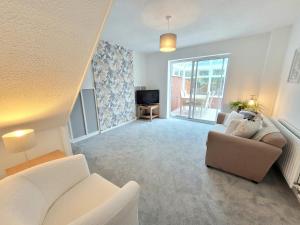 a living room with a couch and a tv at Stay @ Enville Close, Birmingham Airport & NEC in Marston Green