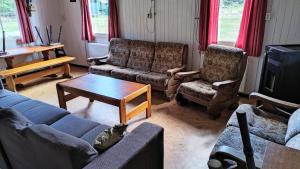 ドゥーティンヘムにあるGroepsaccommodatie - De Ooymanhoeveのリビングルーム(ソファ、椅子、テーブル付)