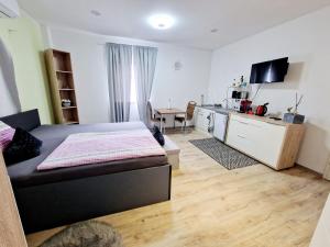 ein Schlafzimmer mit einem Bett und eine Küche mit einem Tisch in der Unterkunft iBO-APART 1 Zimmer Apartment in Herzogenaurach in Herzogenaurach
