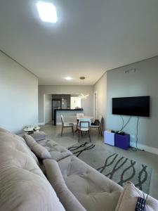 a living room with a couch and a flat screen tv at Vista Panorâmica Enseada in Guarujá