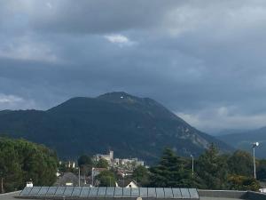 a view of a mountain with a town and a building at *Superbe appartement moderne* in Lourdes