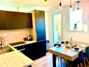 uma cozinha com uma mesa de madeira e um estofamento de estesteryasteryasteryasteryasterestostery em *Superbe appartement moderne* em Lourdes