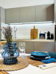 uma mesa com um vaso de vidro azul sobre uma mesa em Tarra Luxury Suite em Milão