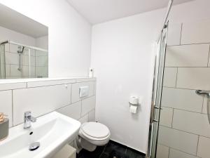a white bathroom with a toilet and a sink at iBO-APART 1 Zimmer Apartment in Herzogenaurach in Herzogenaurach