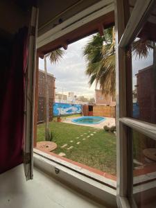 una ventana con vistas a la piscina desde una casa en Open House Hostel en Mendoza