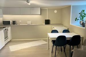 a kitchen with a table and chairs and a counter at One bedroom basement apartment in the city in Tromsø