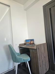 a room with a desk with a laptop and a chair at Apartment Dendrarium Residence in Chişinău