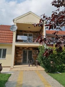 uma casa com uma varanda, uma mesa e cadeiras em Kuća za odmor Jezero em Ostrovo