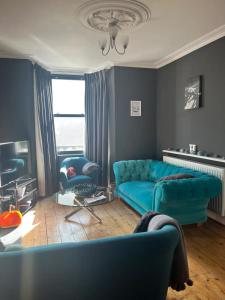 un soggiorno con un divano blu e una sedia di Charming 3BD House wPrivate Garden - Bristol a Bristol