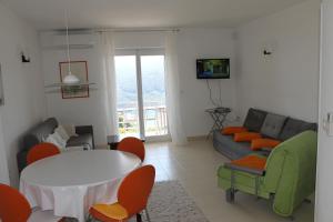 a living room with a couch and a table and chairs at Apartments Vila Marica in Rabac