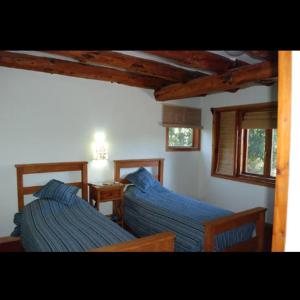 twee bedden met blauwe lakens in een kamer bij SHALOM in Villa La Angostura