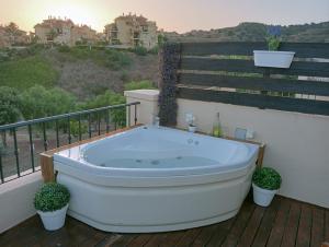 a bath tub sitting on a deck with plants at Holidays2Riviera, Villa 4 bedrooms & 3 bathrooms & Terraces & Jacuzzi & Pool in Mijas
