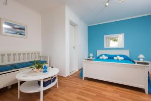 Un dormitorio azul y blanco con una cama y una mesa. en Blue Lagune, en Dubrovnik