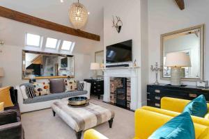 ein Wohnzimmer mit gelben Stühlen und einem Kamin in der Unterkunft Exclusive 3 Bedroom Penthouse - 2 Bath & Mezzanine in Harrogate