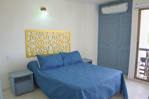 - une chambre avec un lit doté d'une couette bleue et d'une porte dans l'établissement Magico Apartamento con Piscina 1 Habitación PR65, à Montería