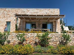 Casa de piedra con ventana y pared de piedra en Trullo il Gatto Nero, en Ostuni