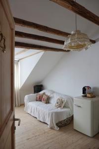 Schlafzimmer mit einem Bett mit weißer Bettwäsche und einem Kühlschrank in der Unterkunft City Hotel Hunsrücker Hof in Boppard