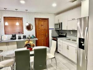 uma cozinha com mesa e cadeiras e uma cozinha com armários brancos em GREAT LOCATION Downtown/Airport/South Beach em Miami
