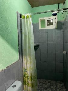 y baño con cortina de ducha y aseo. en Casa Julia Xela, en Quetzaltenango