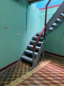 a staircase with a red railing in a room at Casa Julia Xela in Quetzaltenango