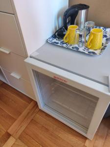 a counter with two yellow mugs on a tray at Hlinená izba na Hájiku in Banská Štiavnica