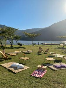 a group of picnic tables in the grass near a lake at Villa Amore Floripa in Florianópolis