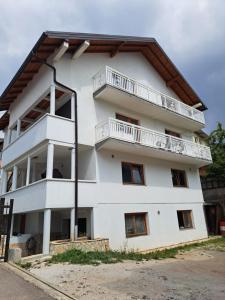 a white building with balconies on top of it at Apartments Neyla in Sarajevo