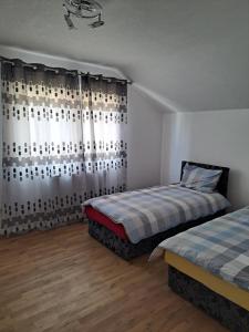 a bedroom with two beds and a curtain at Apartments Neyla in Sarajevo